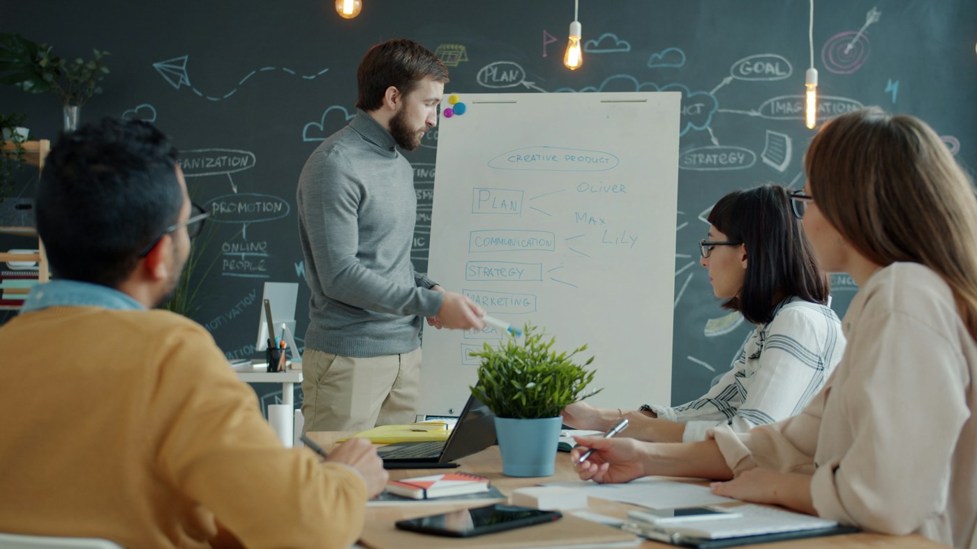 A team discussing a project plan at a whiteboard